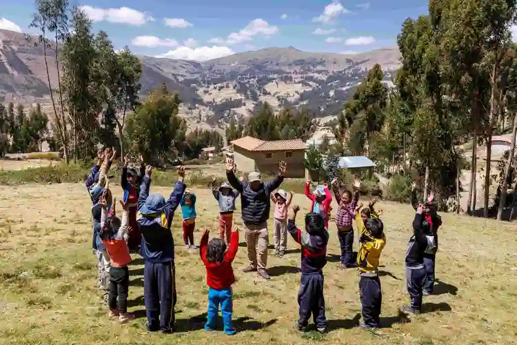 children in circle with mountainous background